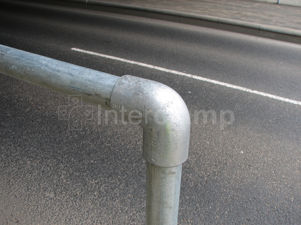 Close-up of Interclamp standard safety stanchion posts offering reliable protection for pedestrians walking along a busy main road.